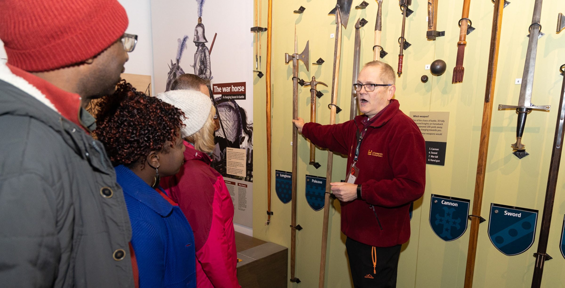 Exhibition Volunteer Explainignn Aout The Weapons Wall In Preparing For Battle Aspect Ratio 785 400