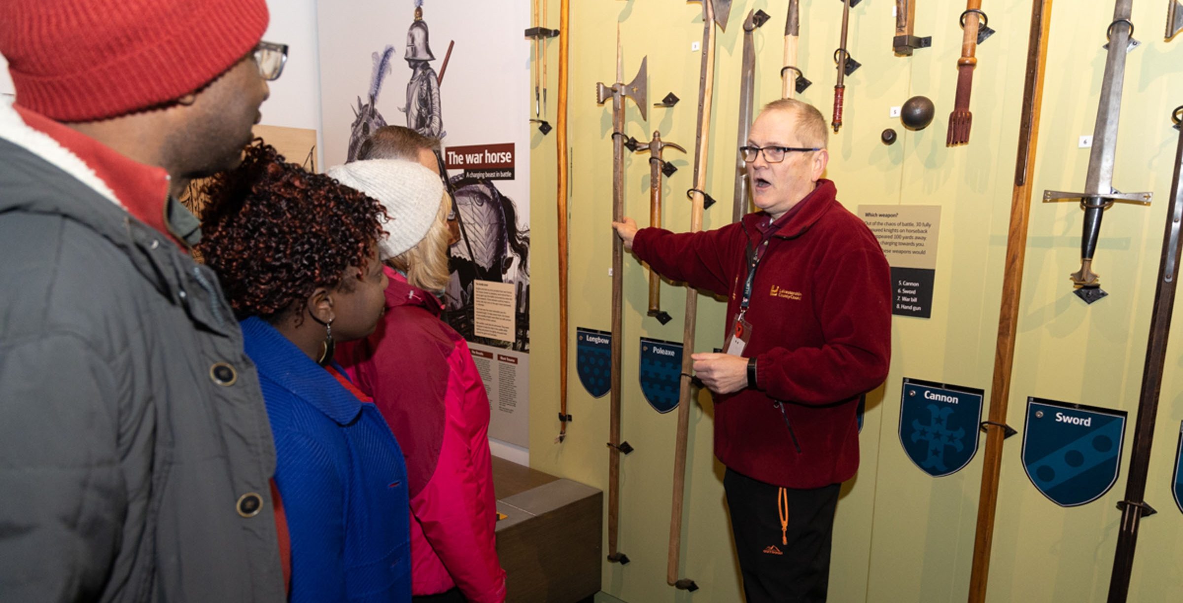 Exhibition Volunteer Explainignn Aout The Weapons Wall In Preparing For Battle Aspect Ratio 785 400